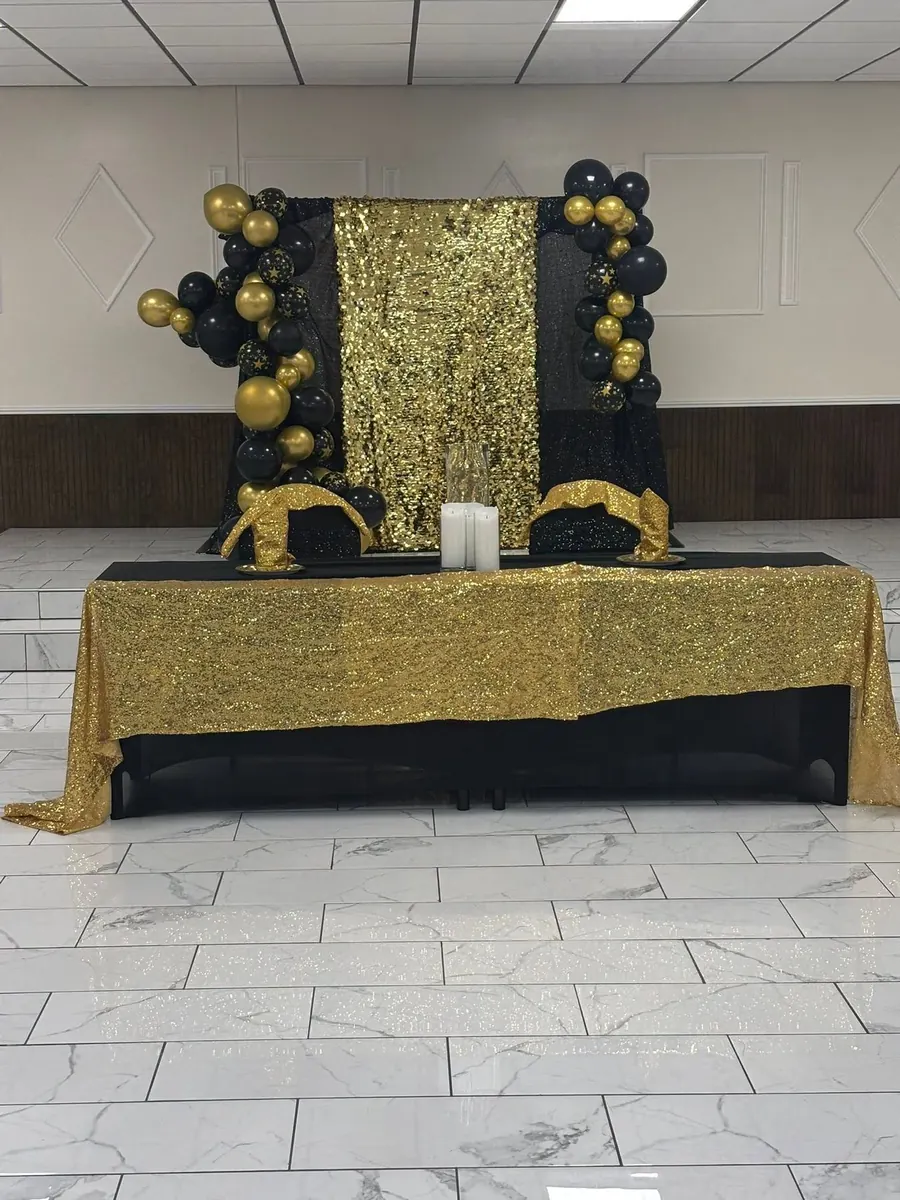 Gold sequin dessert table with black and gold balloons