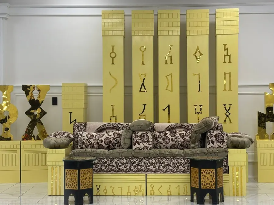 Gold stage backdrop with a patterned sofa
