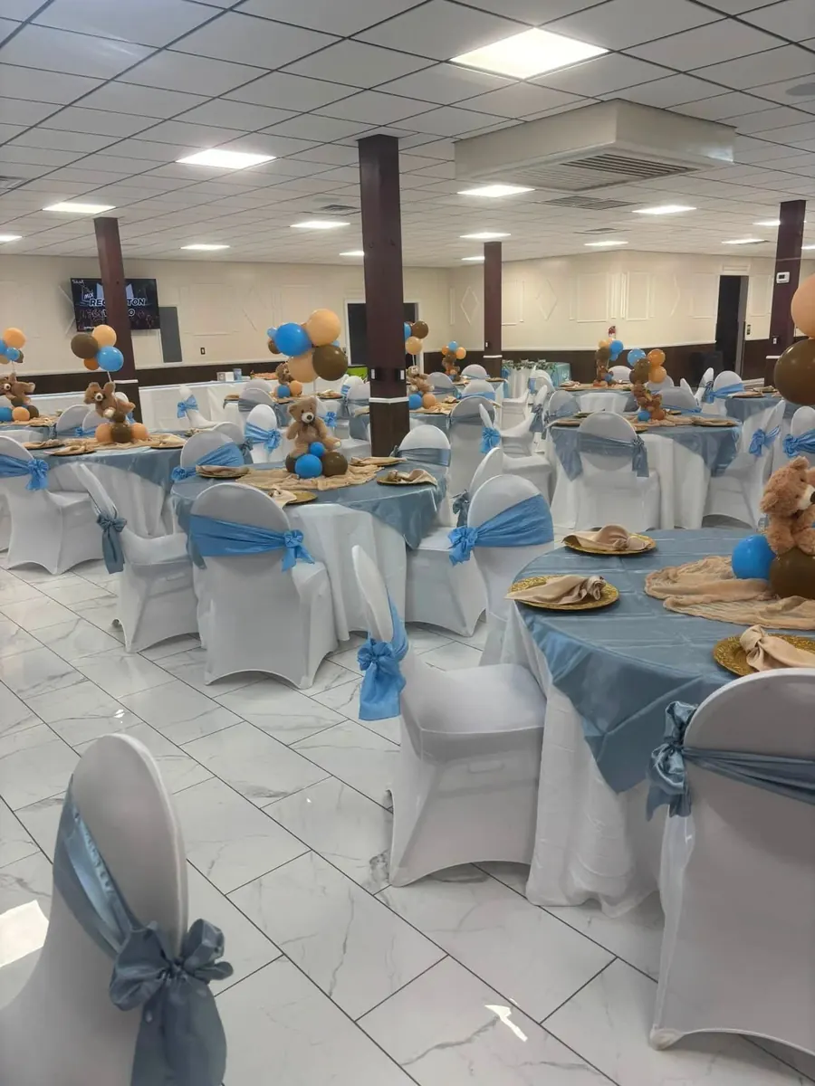 Baby blue sashes and gold chargers on white tables