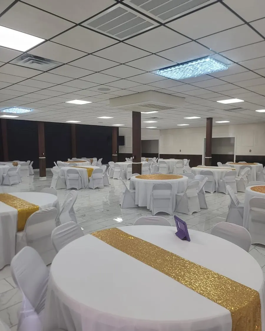 White table with a gold sequin runner and place settings